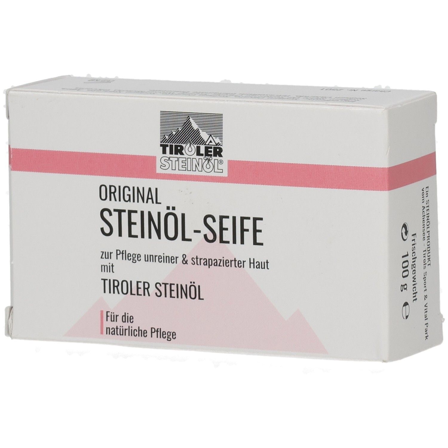 Weiße Kartonverpackung mit rosa Streifen. Aufschrift: ORIGINAL STEINÖL-SEIFE, TIROLER STEINÖL. 100 g.