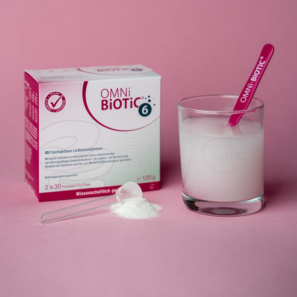 OMNi-BiOTiC® 6 Verpackung, Glas mit aufgelöstem Pulver und Löffel.