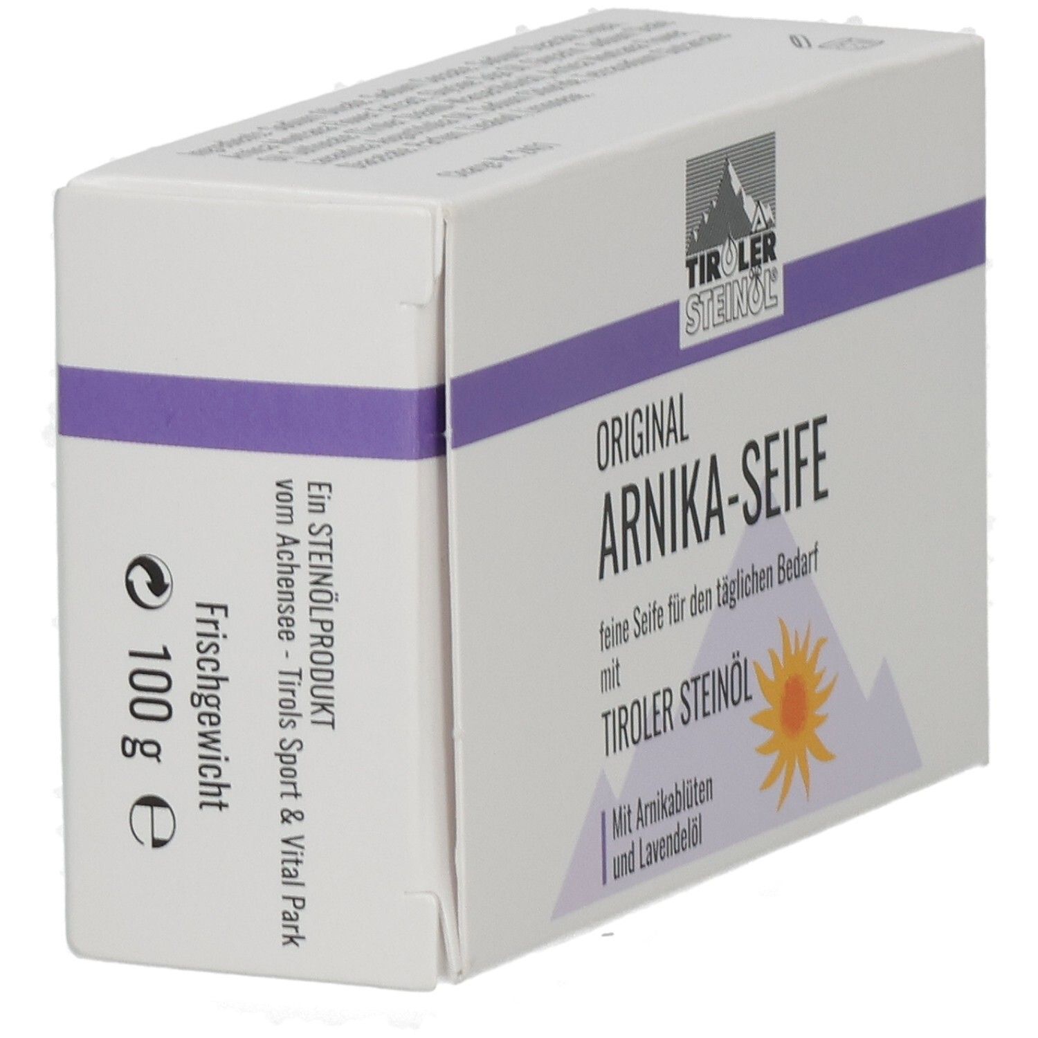 Weißer Karton mit lila Streifen. Aufschrift: ORIGINAL ARNIKA-SEIFE, TIROLER STEINOEL. Mit Arnikablüten & Lavendelöl. 100 g.