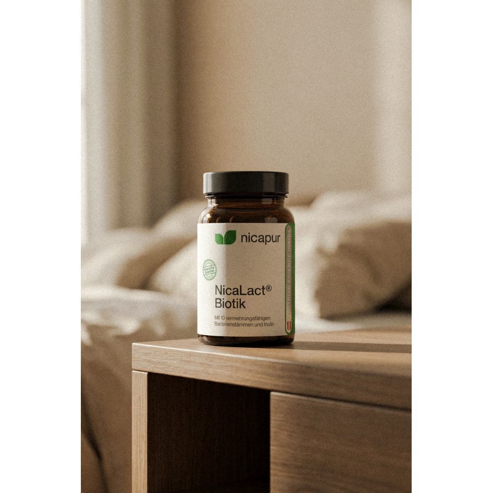 NICApur NicaLact Biotik Kapseln in brauner Glasflasche auf Nachttisch.