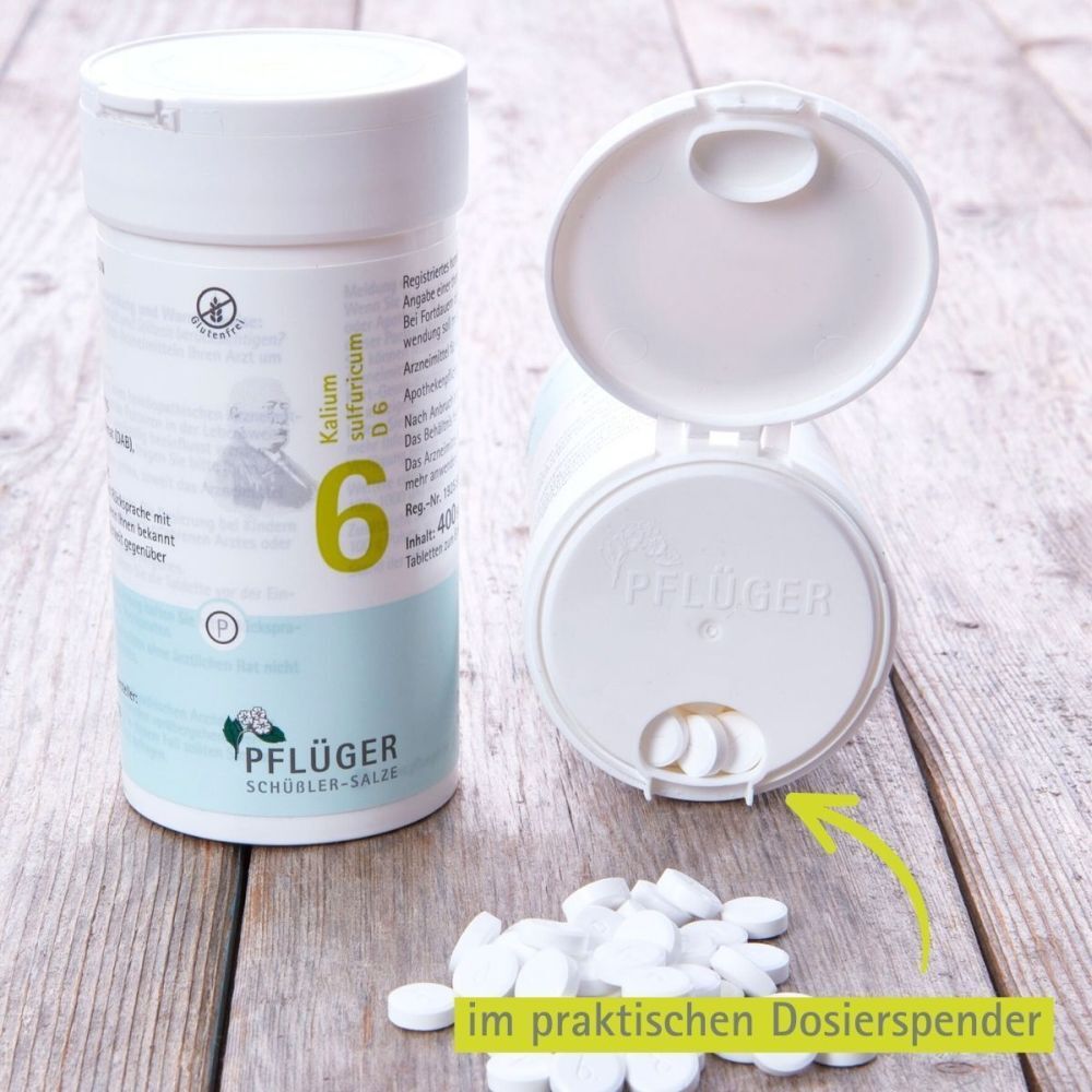 Weiße Tabletten aus einer Dose. Aufschrift: Pflüger Schüßler-Salze, 6, Kalium sulfuricum D6.