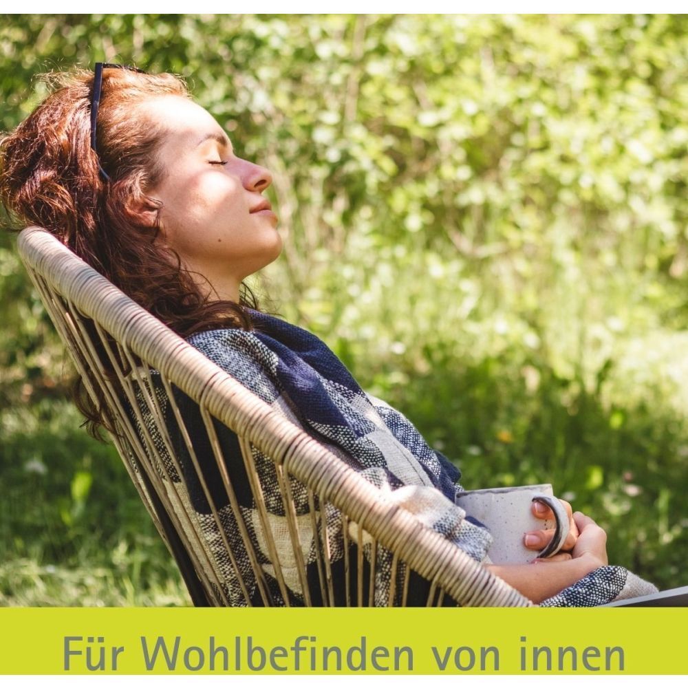 Frau sitzt entspannt in einem Stuhl. Text: Für Wohlbefinden von innen.