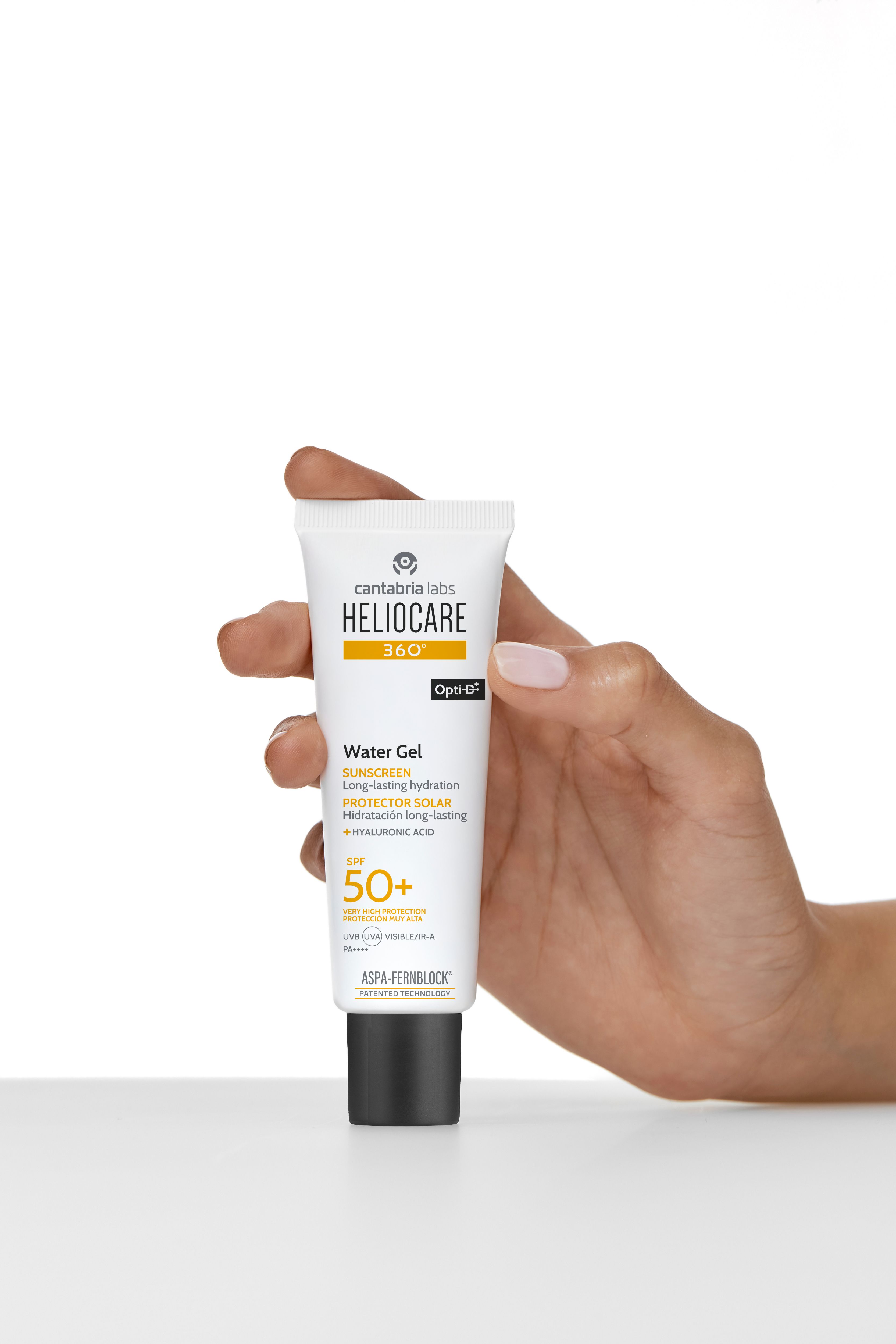 Hand hält Tube HELIOCARE 360° Water Gel LSF 50+. Weiß, schwarzer Deckel. Aufschrift: SUNSCREEN, SPF 50+.