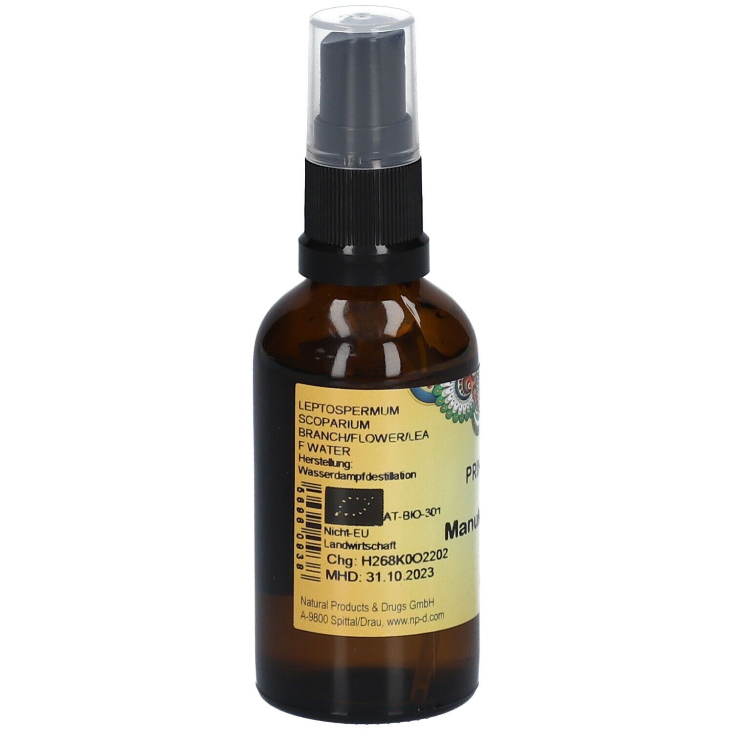 Braune Glasflasche mit Sprühkopf. Etikett mit Inhaltsstoffen und Chargennummer. Aufschrift: PRIMABENE Manukawasser BIO.