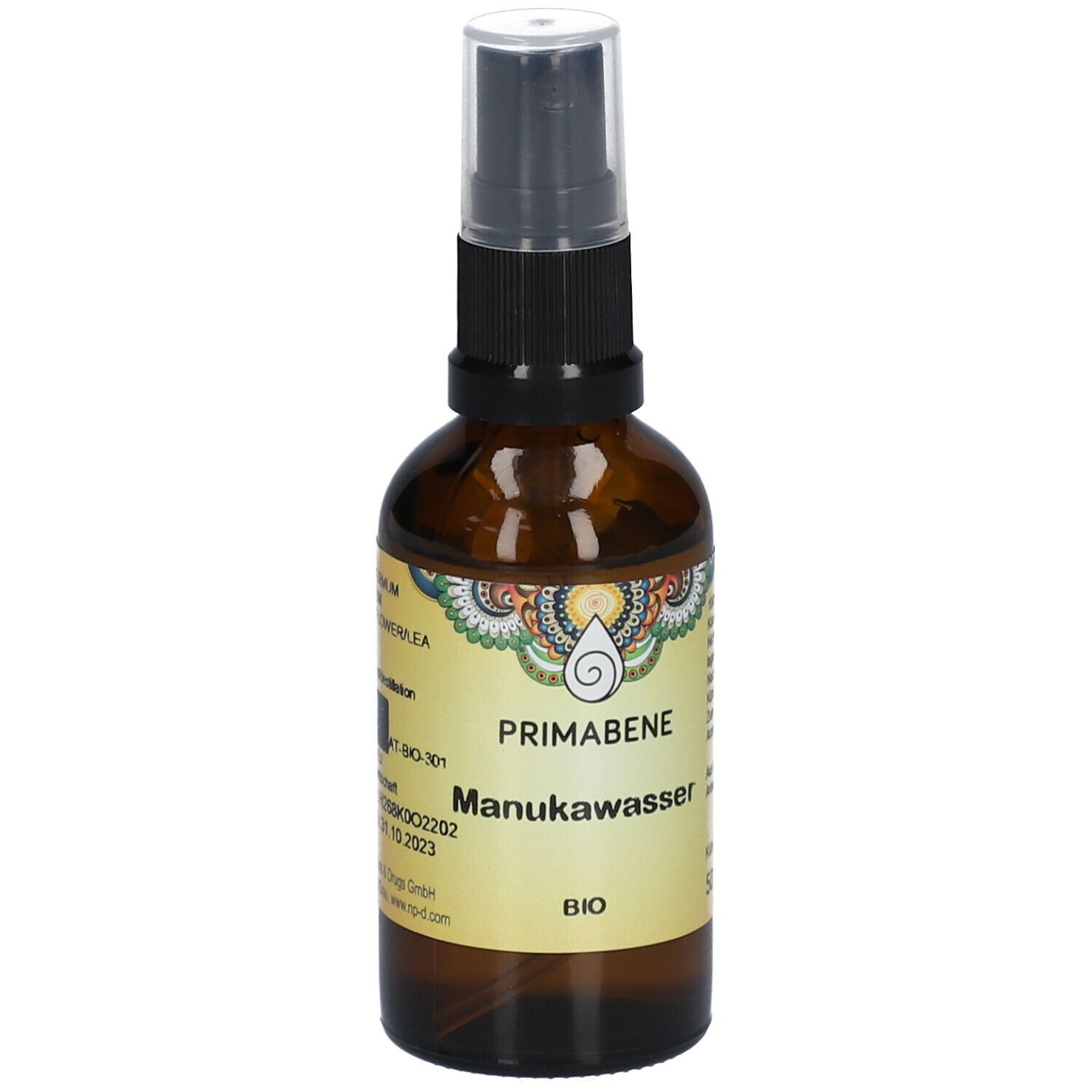 Braune Glasflasche mit Sprühkopf. Aufschrift: PRIMABENE Manukawasser BIO. Etikett mit Logo und Text.