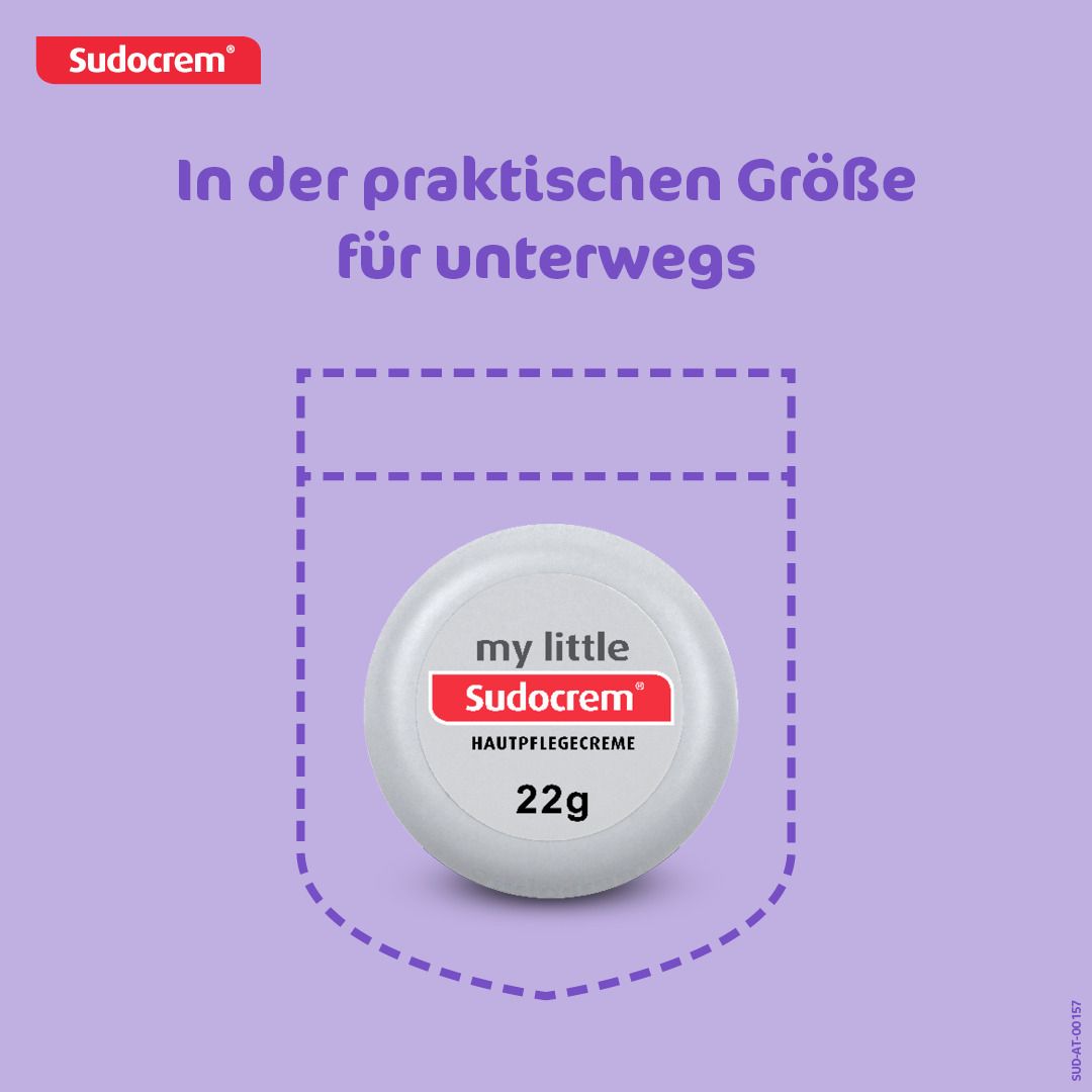 Weiße, runde Dose mit rotem und weißem Etikett. Aufschrift: my little Sudocrem, Hautpflegecreme, 22g. Abgebildet in einer Hosentasche.