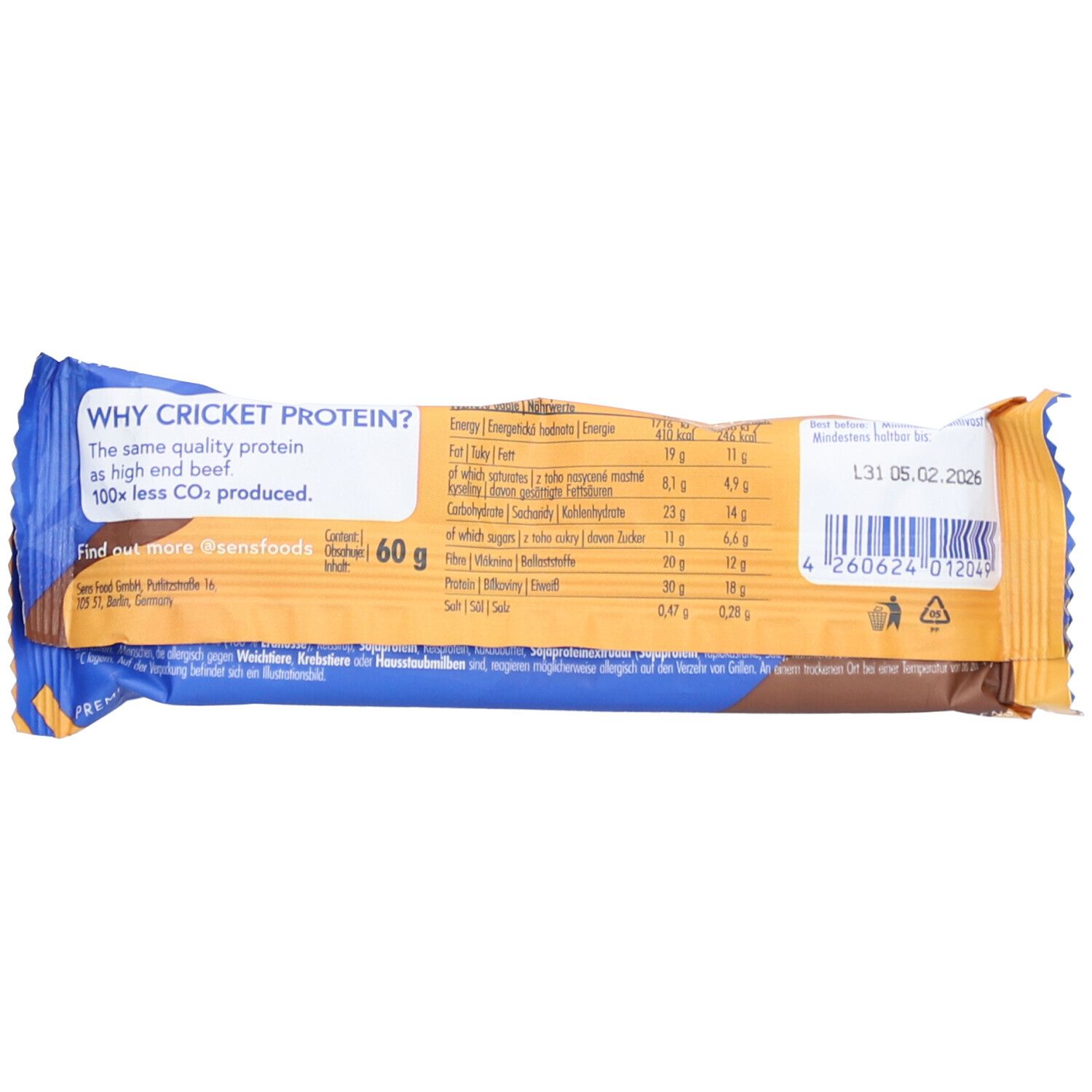Rückseite des Proteinriegels. Blaue und braune Verpackung mit Nährwertangaben, Text und Barcode.