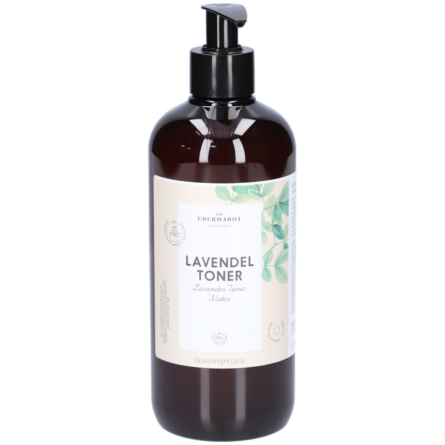 Braune Flasche mit schwarzem Pumpkopf. Aufschrift: LAVENDEL TONER. Mit grünen Blättern dekoriert.