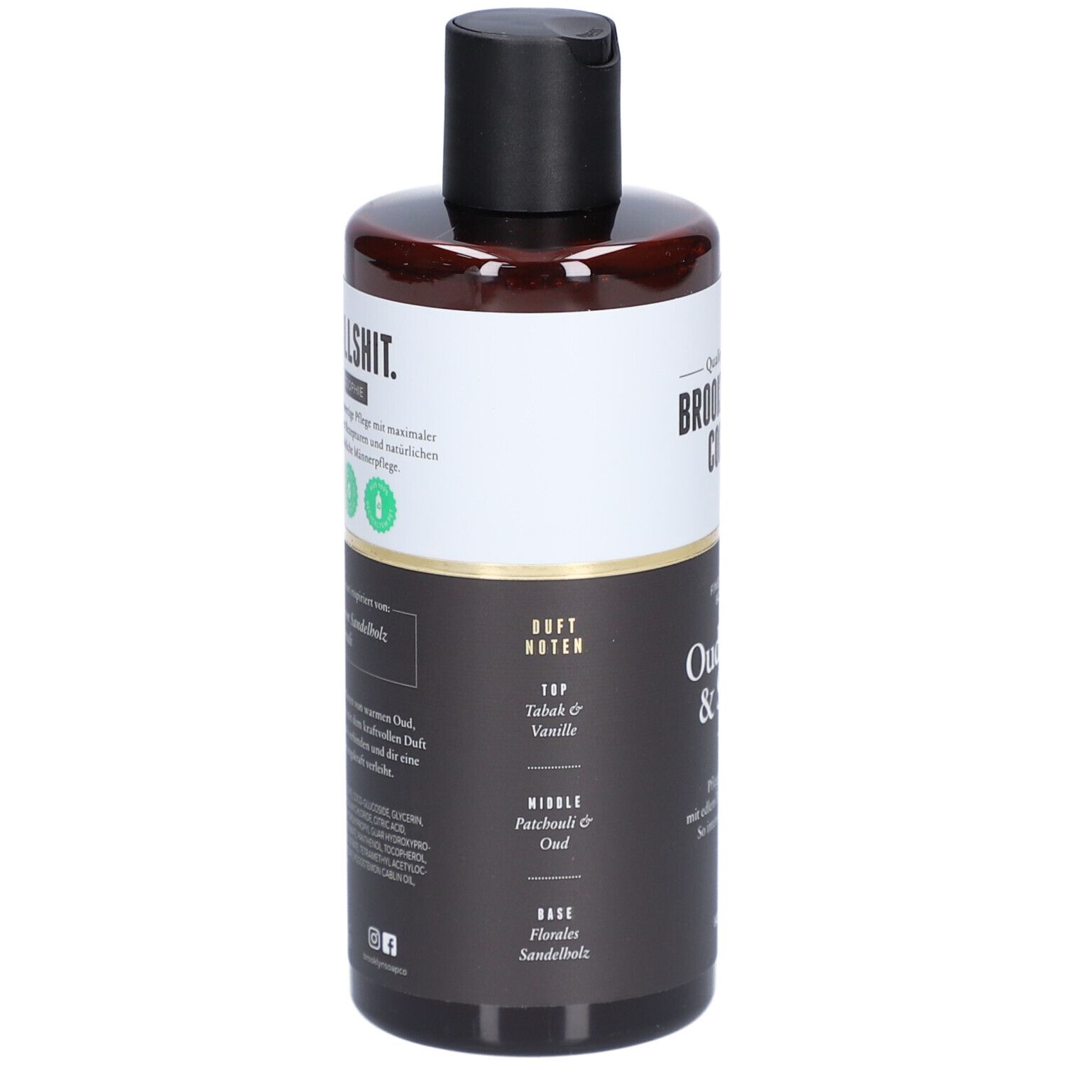 Rückseite der braunen Flasche. Aufschrift: Duftnoten, Top: Talk & Vanille, Mittle: Patchouli & Oud, Base: Sandelholz.