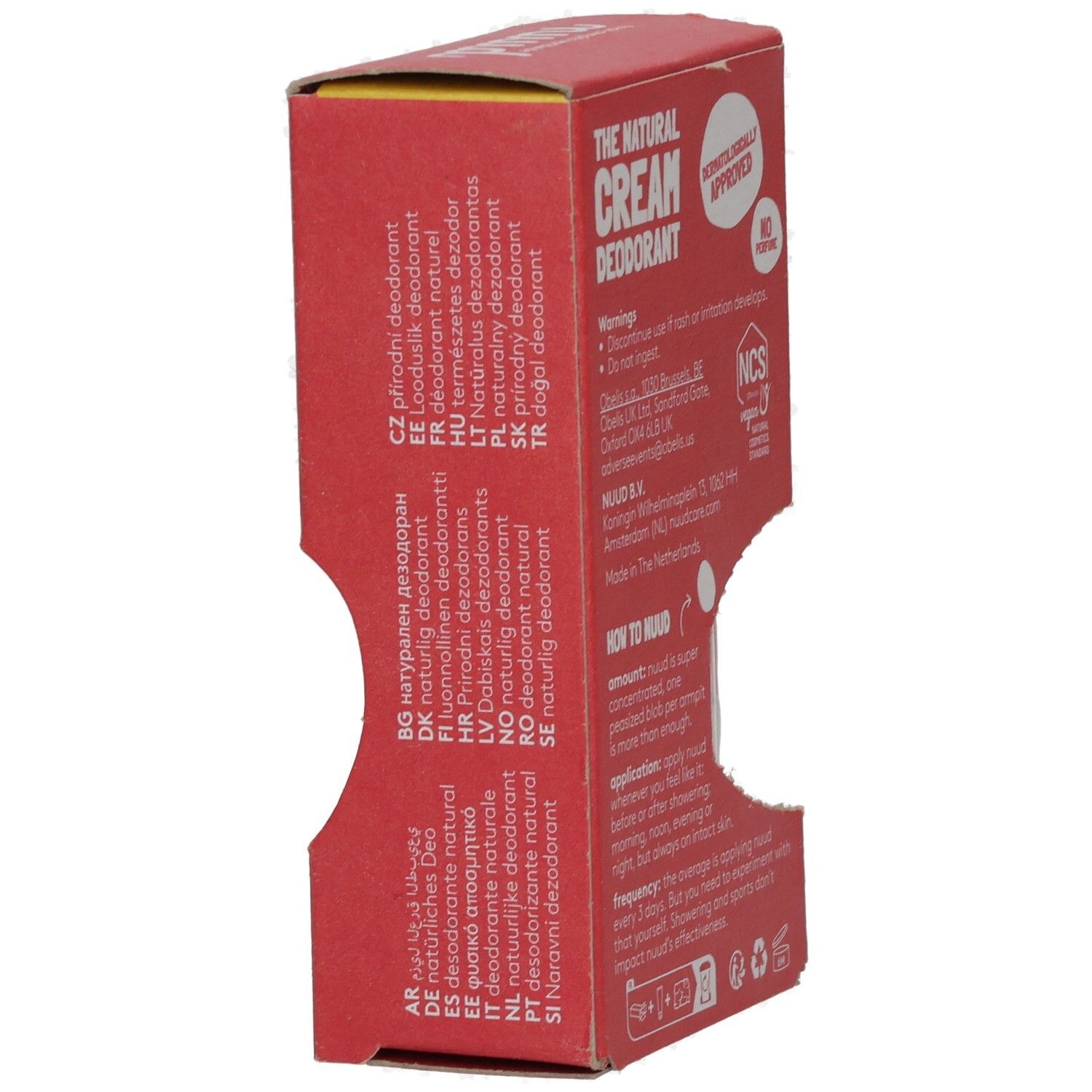Rote Pappverpackung mit Text. Text: The Natural Cream Deodorant, dermatologisch getest, ohne Parfüm. Mehrsprachige Informationen und Logos.