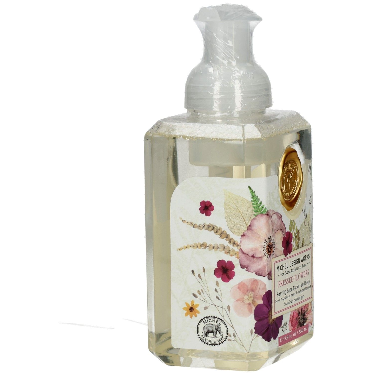 Seifenspender mit floralem Design. Aufschrift: Pressed Flowers, Foaming Shea Butter Hand Soap. Sichtbare Marke: Michel Design Works.