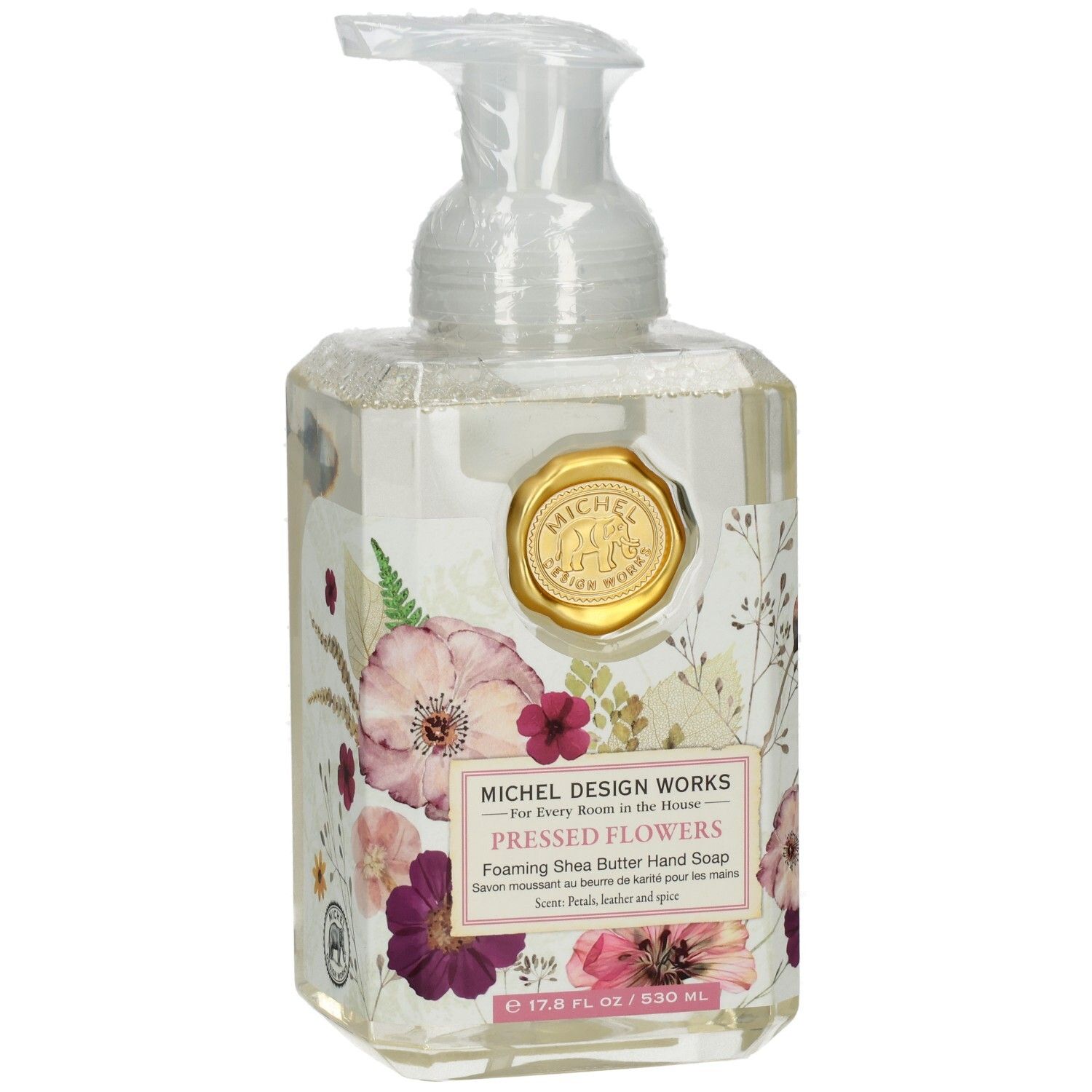 Klarer Seifenspender mit floralem Design und goldenem Siegel. Aufschrift: Pressed Flowers, Foaming Shea Butter Hand Soap.