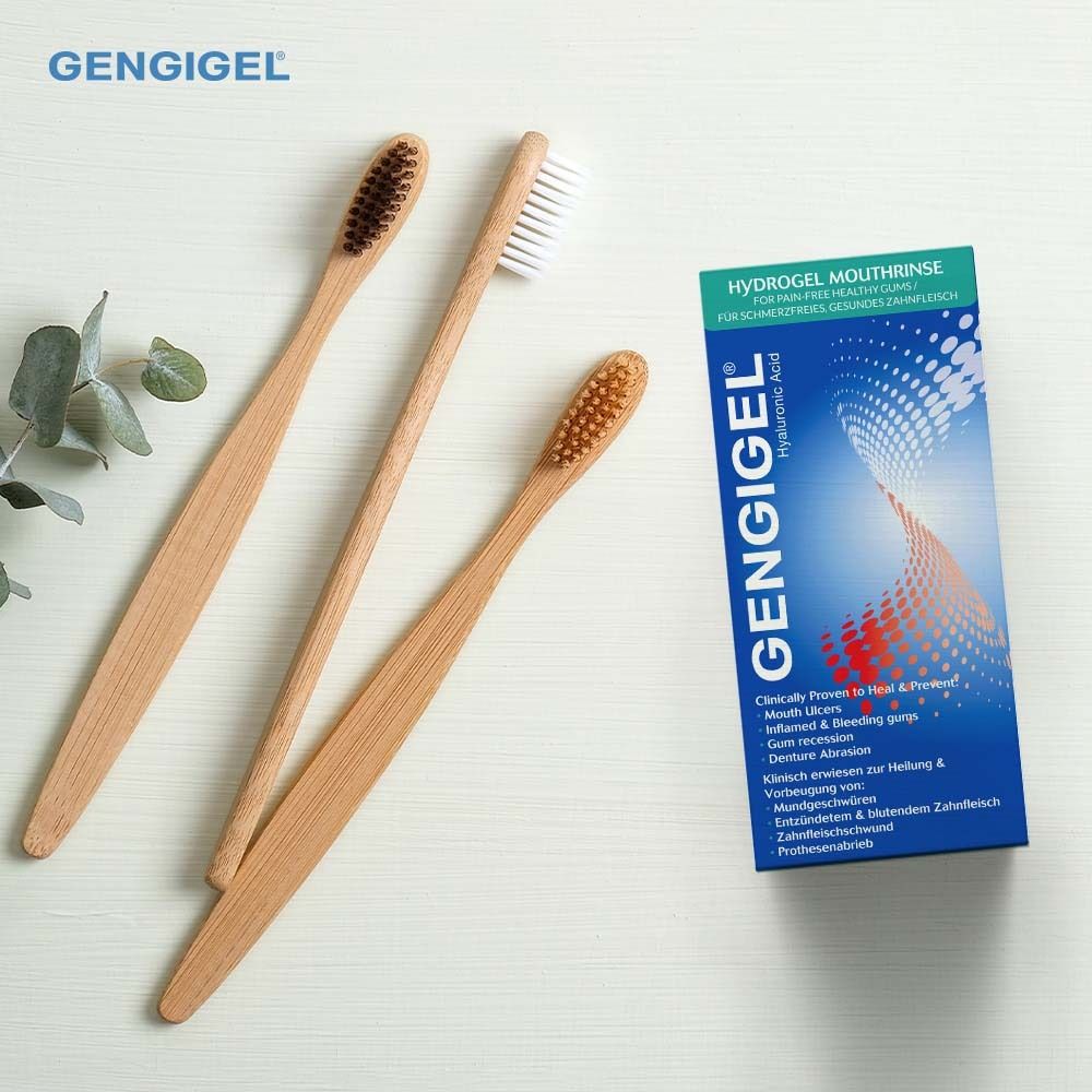 Drei Zahnbürsten und Gengigel Verpackung. Auf weißem Untergrund mit grünen Blättern.