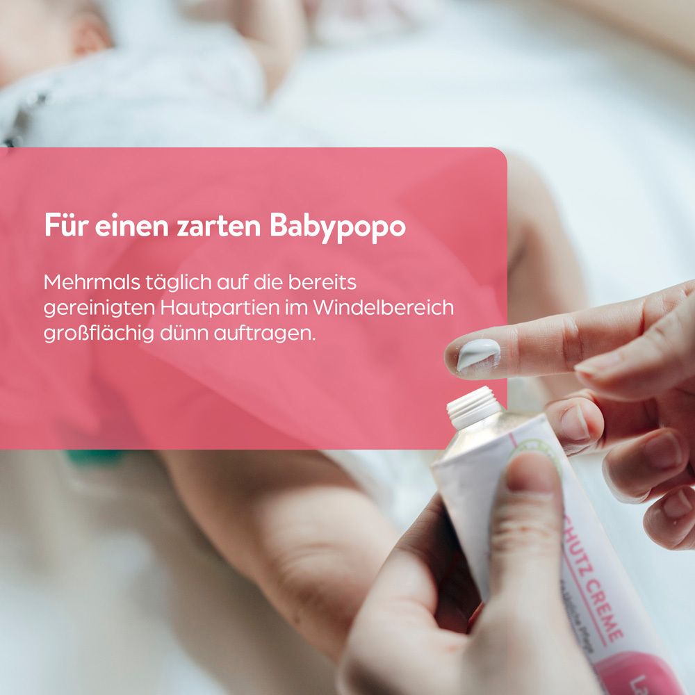 Eine Hand trägt Lasepton Baby Schutz-Creme auf den Po eines Babys auf.