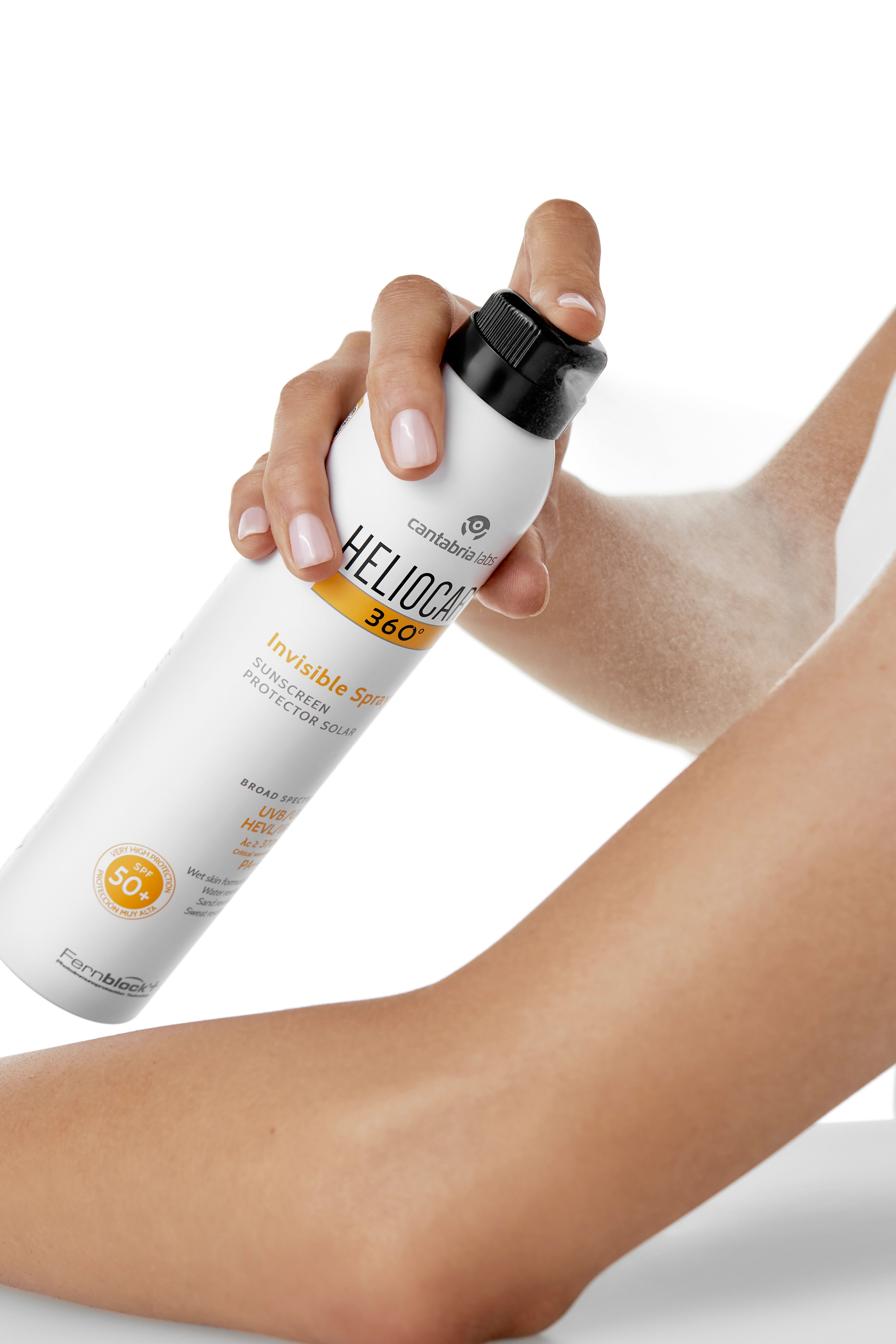 Weißes Spray wird auf Arm gesprüht. Aufschrift: HELIOCARE 360° Invisible Spray LSF 50+. Gelber Streifen mit Text.