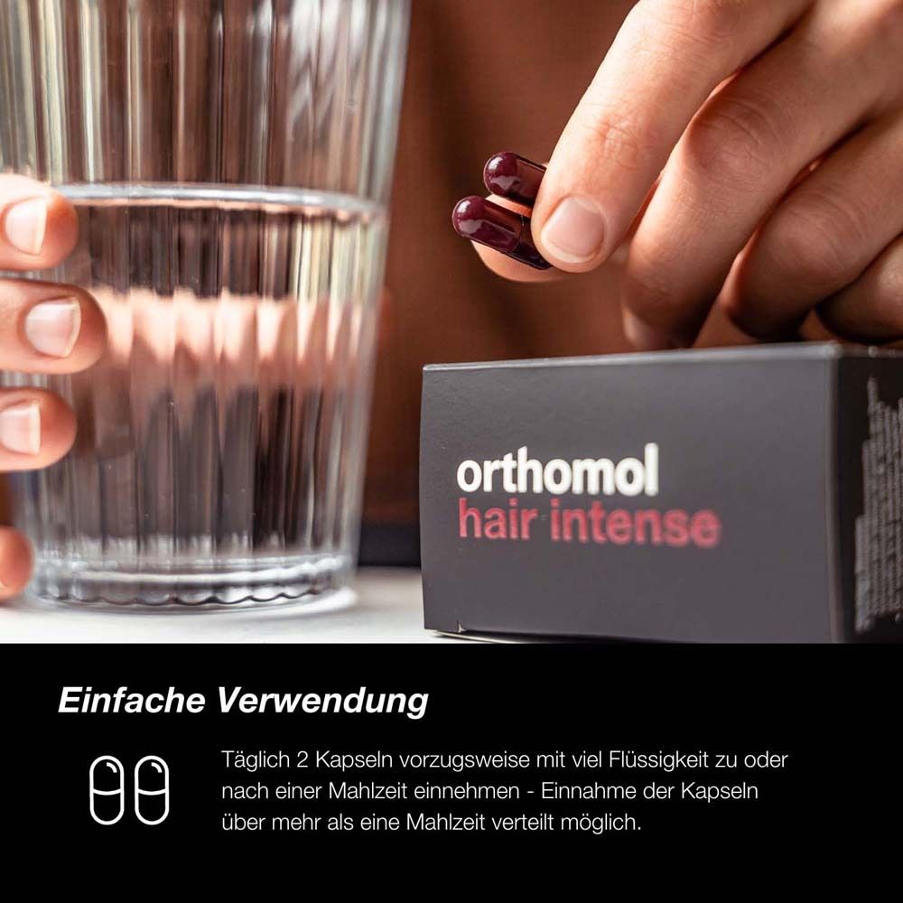 Person nimmt Kapseln mit Wasser ein. Schachtel Orthomol Hair Intense im Hintergrund.