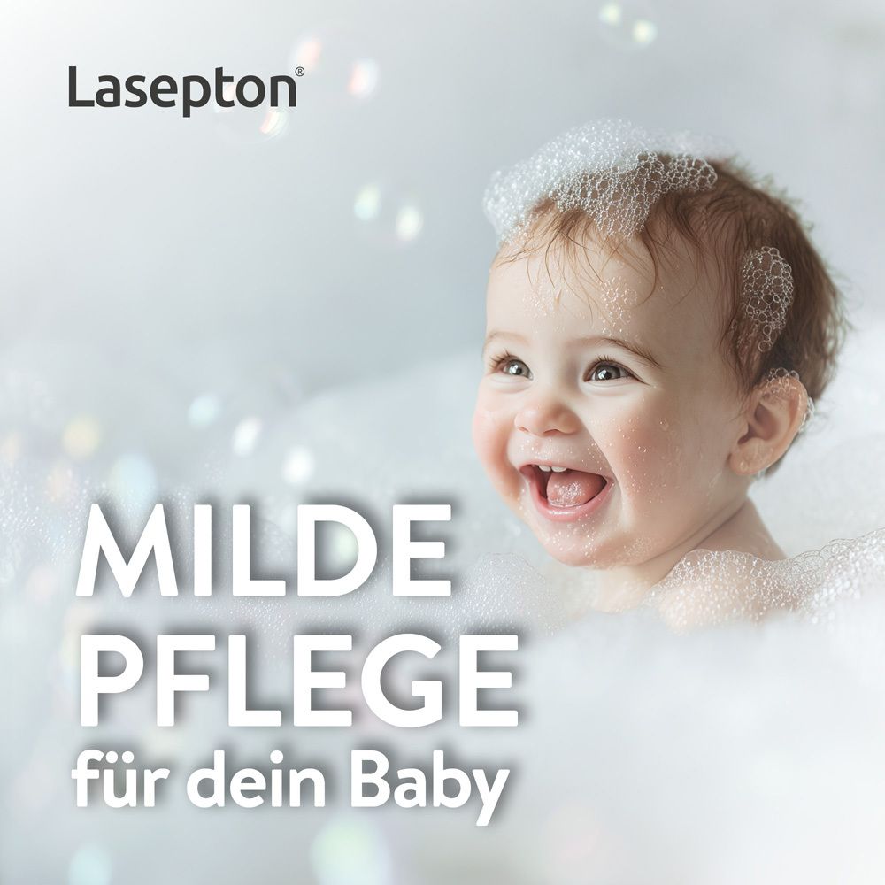 Lächelndes Baby in Schaum und Seifenblasen, mit Text "Milde Pflege für dein Baby".