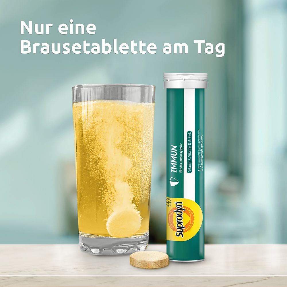 Glas mit sprudelnder Flüssigkeit und Brausetablette. Daneben eine Tube Supradyn IMMUN.