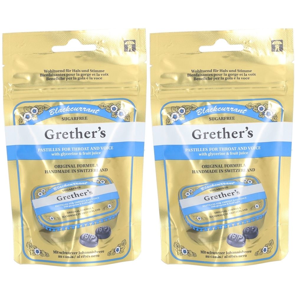 Zwei goldfarbene Beutel mit Grether's Blackcurrant Pastillen. Blaue und weiße Etiketten mit Produktnamen und Text. Sichtbare Pastillen.