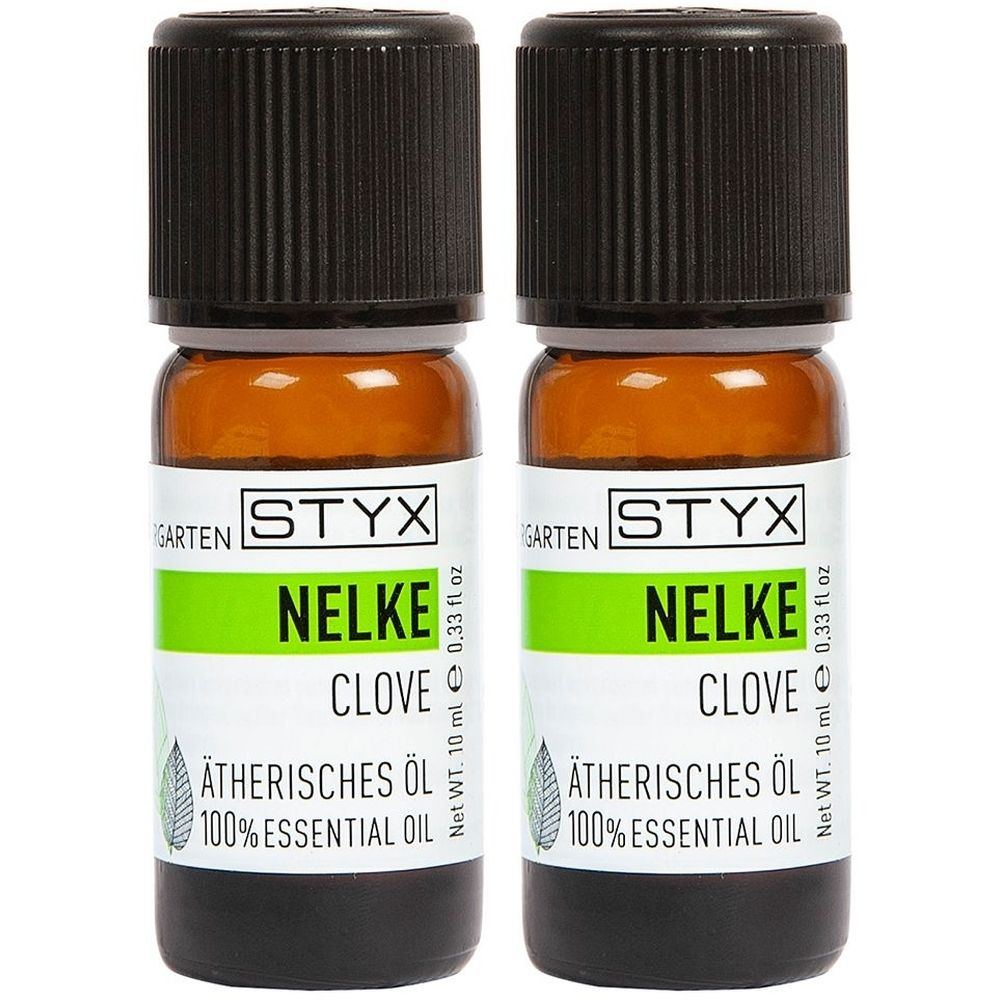 Zwei braune Glasflaschen mit schwarzem Deckel. Aufschrift: STYX, Nelke, Ätherisches Öl. Grüne und weiße Etiketten.