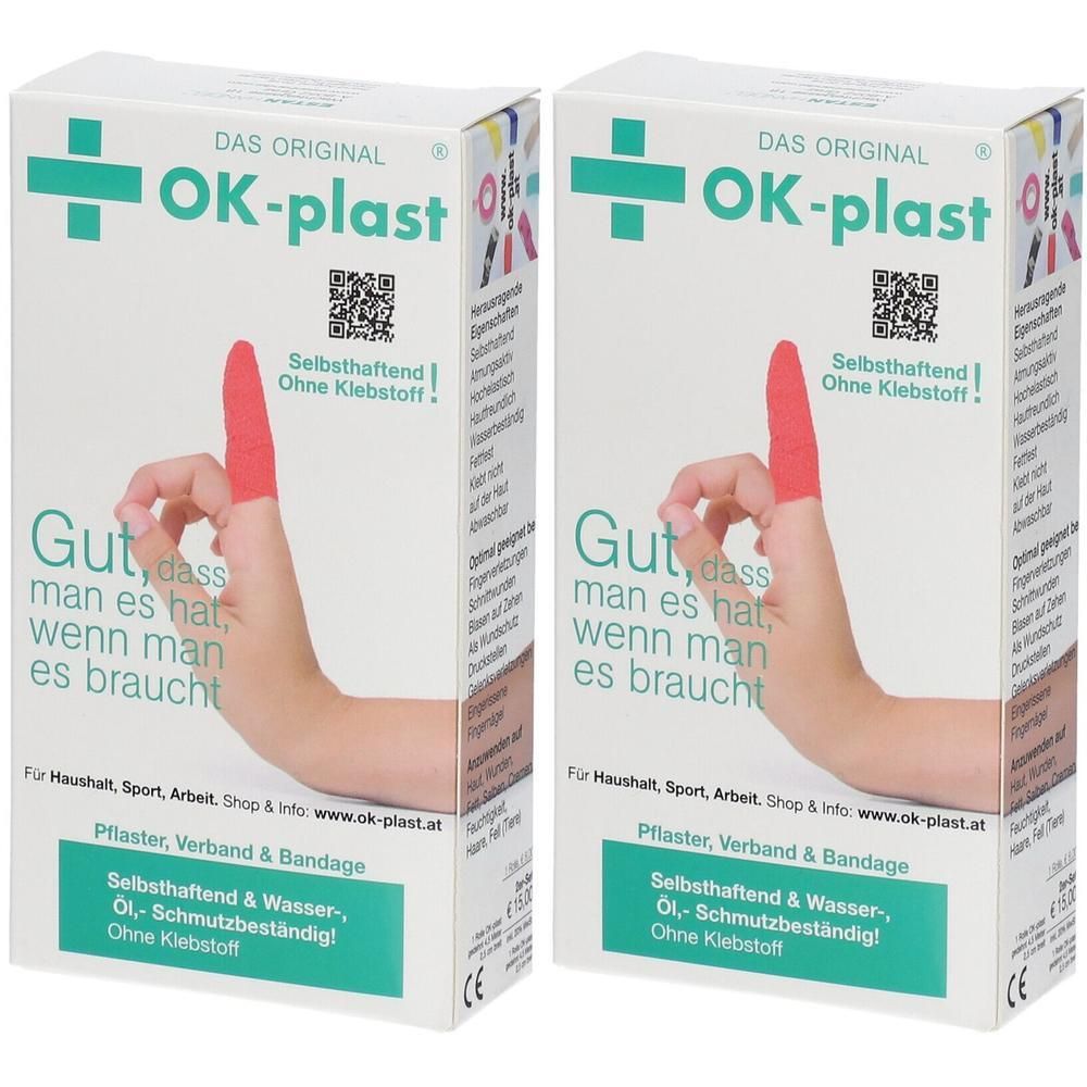 Zwei Packungen OK-Plast Pflaster. Ein Finger trägt ein rotes, selbsthaftendes Verbandmaterial ohne Klebstoff.