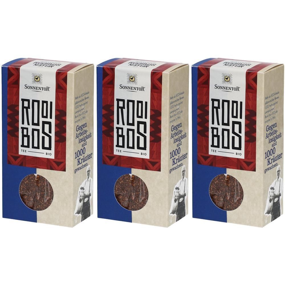 Drei Packungen Sonnentor Rooibos Tee lose, Bio. Rote und blaue Verpackung mit Schriftzug und Kräutern.