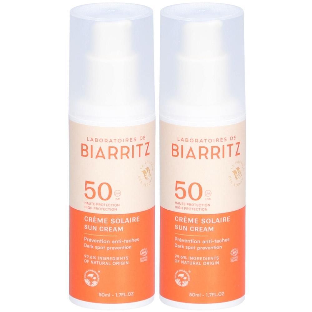 Zwei Flaschen Sonnencreme mit weißem Deckel. Aufschrift: BIARRITZ, 50, Crème Solaire Sun Cream. Orangefarbener Aufdruck.