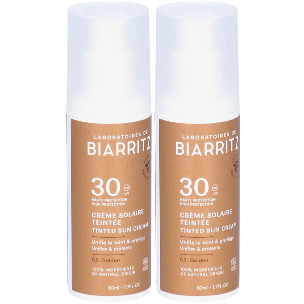 Zwei Flaschen Sonnencreme. Aufschrift: Laboratoires de Biarritz, 30 SPF, getönte Sonnencreme. Farbe: Gold. Bio-zertifiziert.