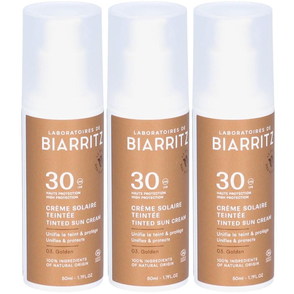 Drei Flaschen Sonnencreme. Aufschrift: Laboratoires de Biarritz, 30, Crème Solaire Teintée, 03. Golden. Bio-Zertifizierung.