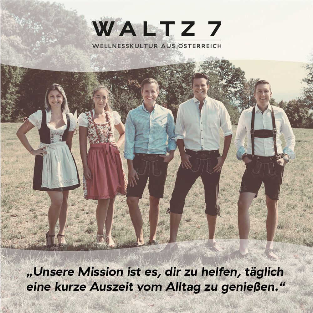Vier Personen in Tracht vor grüner Wiese. Text: Unsere Mission ist es, dir zu helfen, täglich eine kurze Auszeit vom Alltag zu genießen.