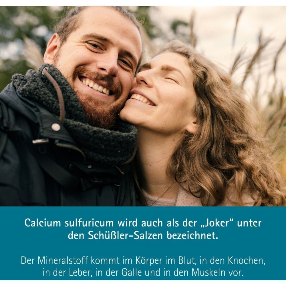 Ein Paar lächelt, umgeben von Schilf. Text über Calcium sulfuricum als Schüssler-Salz.