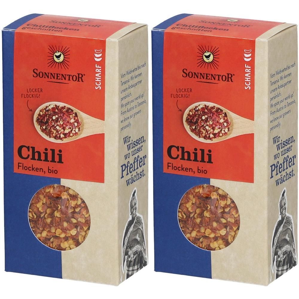 Zwei rechteckige Kartonverpackungen mit rotem Chili-Flocken-Bio-Aufdruck. Marke: SONNENTOR. Aufschrift: Scharf.