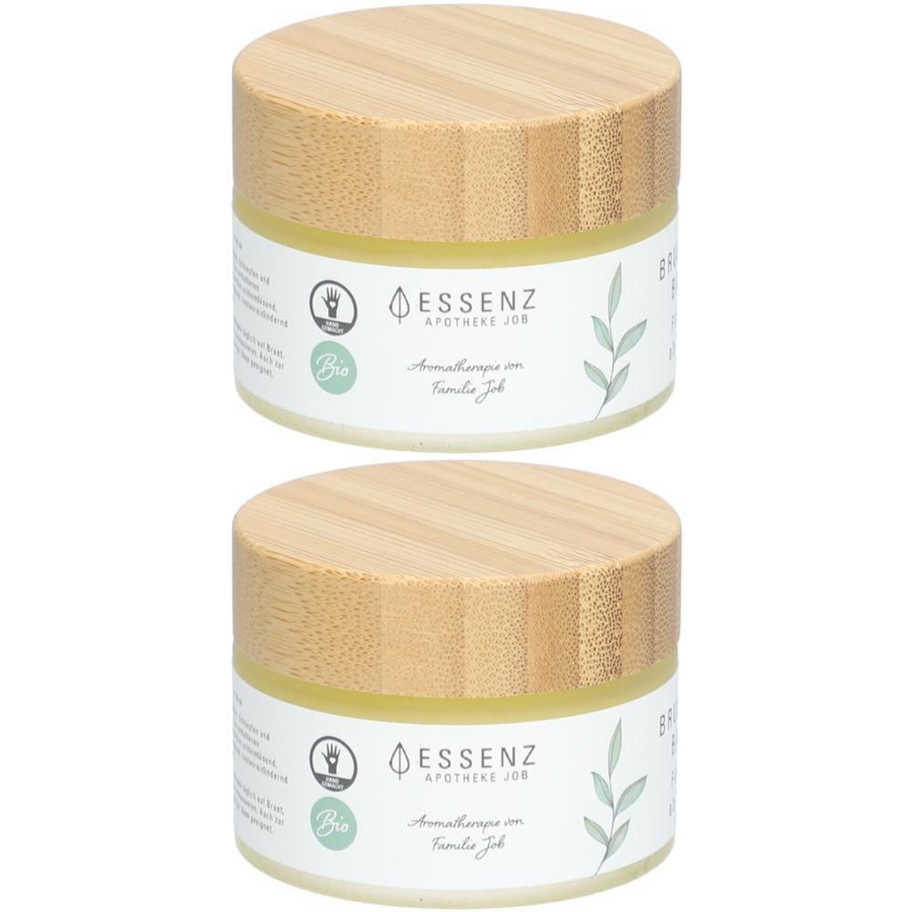 Zwei runde Tiegel mit Holzdeckel. Etikett mit "ESSENZ APOTHEKE JOS" und "Bio".