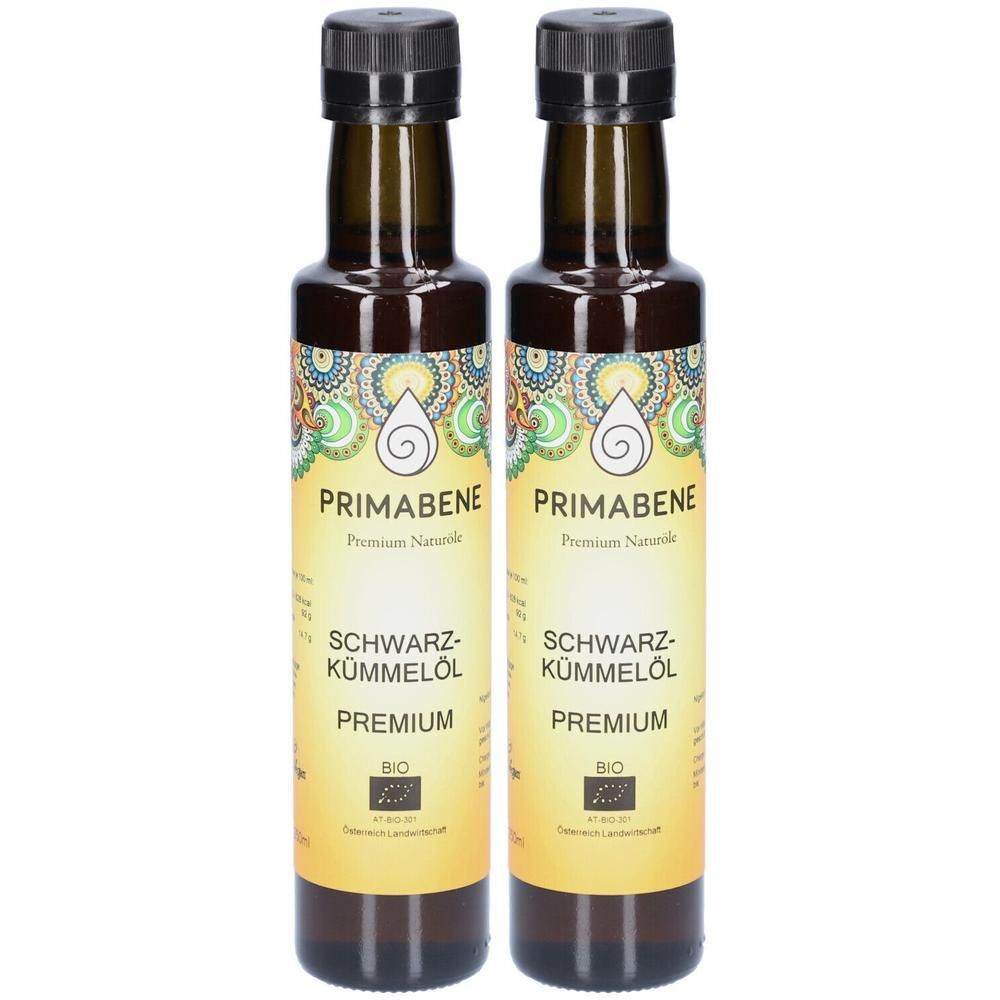 Zwei Flaschen PRIMABENE Schwarzkümmelöl PREMIUM BIO. Braune Glasflaschen mit schwarzem Deckel und gelbem Etikett mit Logo und Text.