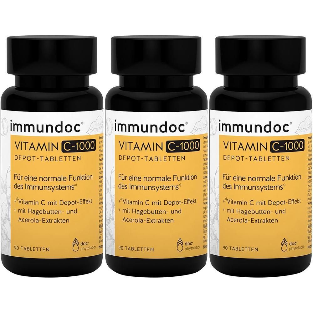 Drei Flaschen immundoc Vitamin C-1000 Depot-Tabletten. Schwarze Deckel, gelbe Etiketten mit Text. 90 Tabletten pro Flasche.