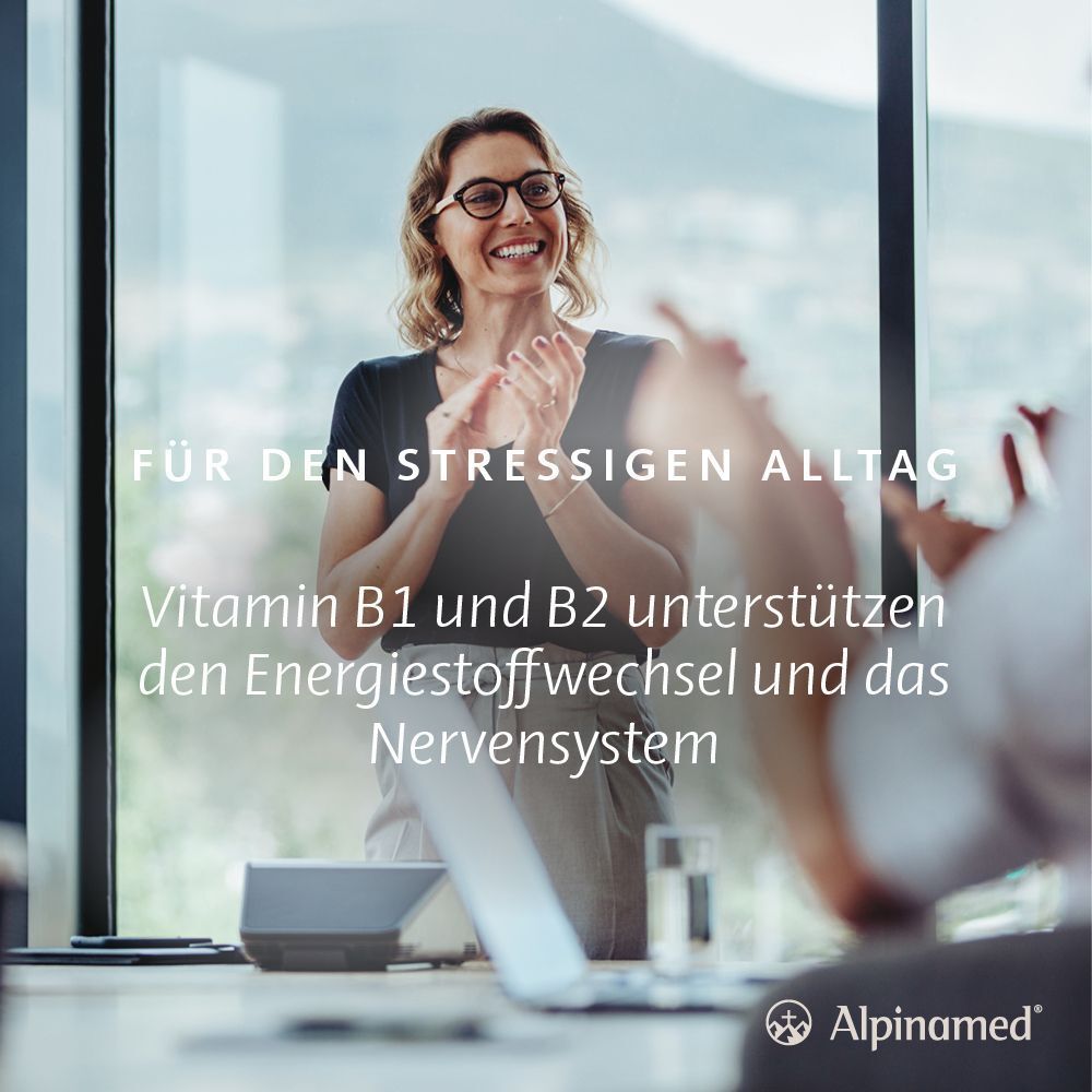 Frau klatscht in Büro. Text: Für den stressigen Alltag. Vitamin B1 und B2 unterstützen den Energiestoffwechsel und das Nervensystem.