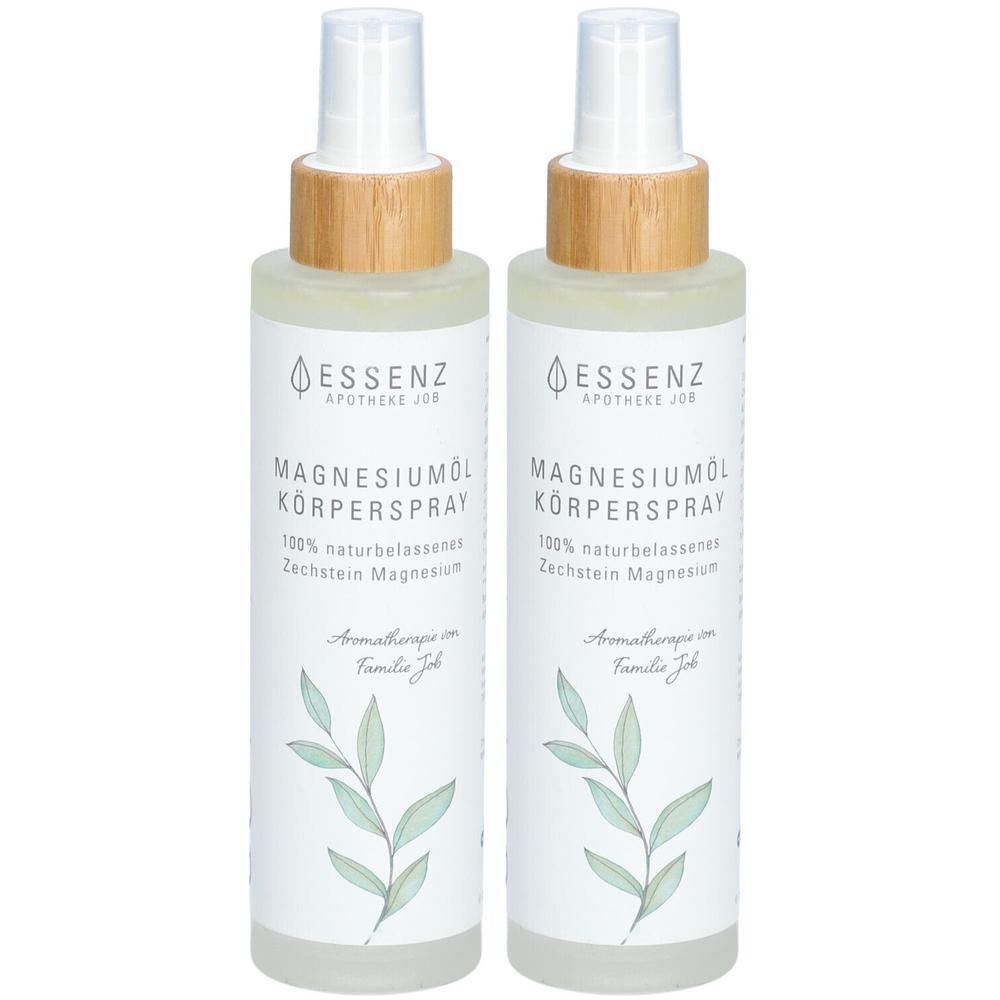 Zwei Sprühflaschen mit Magnesiumöl Körperspray. Klare Flüssigkeit, weiße Etiketten mit grünen Blättermotiven und Holzverschlüssen.