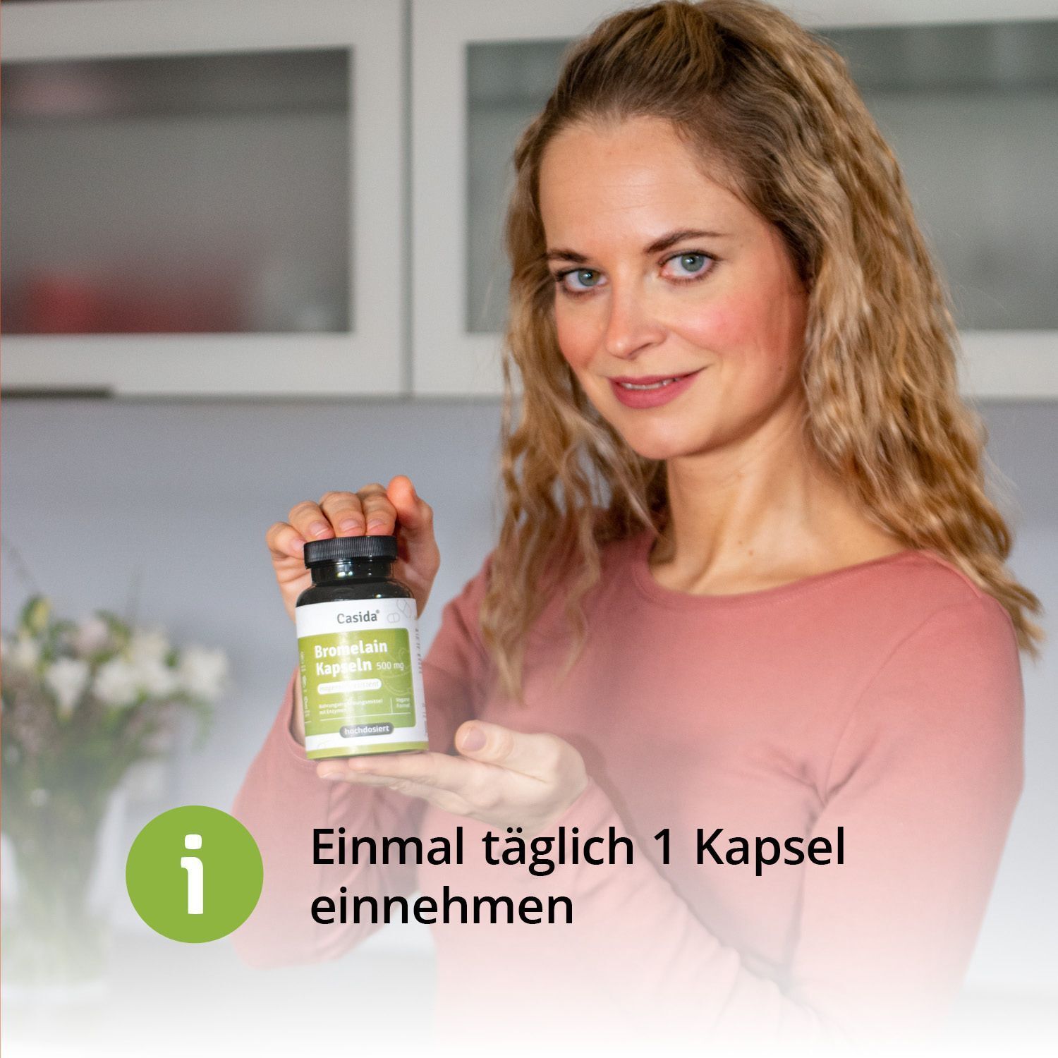 Frau hält eine Flasche Casida® Bromelain 500 mg. Flasche mit grünem Etikett. Text: Einmal täglich 1 Kapsel einnehmen.