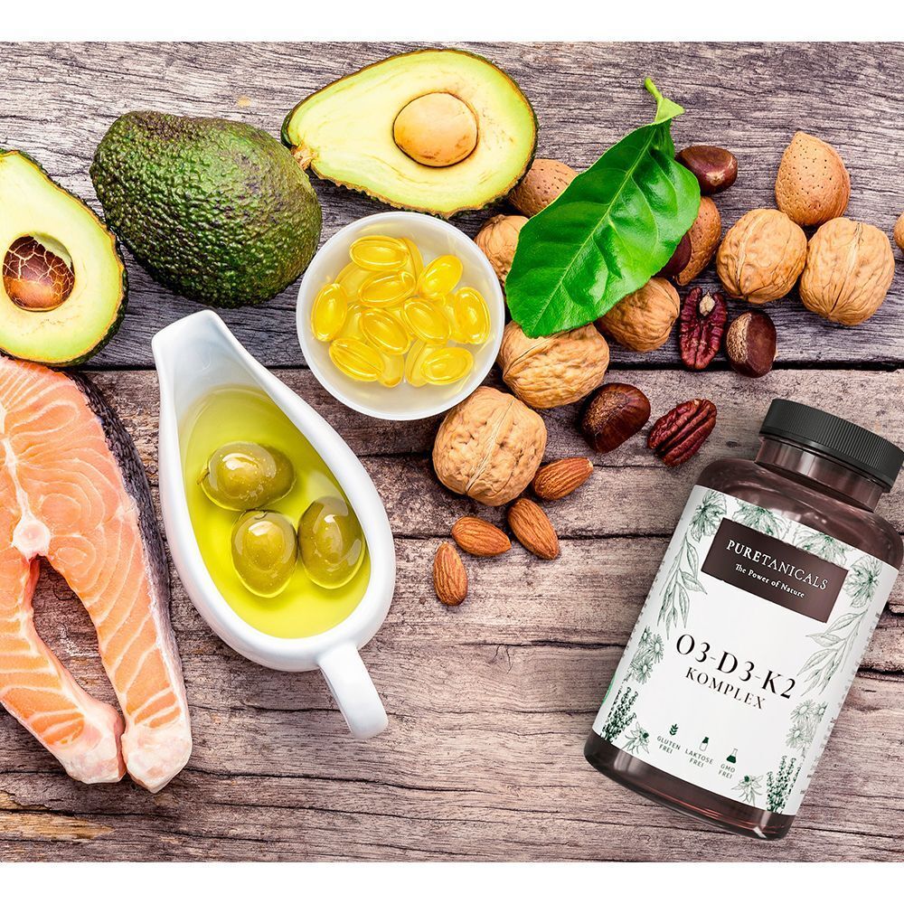 Braune Flasche mit Etikett neben Avocado, Nüssen, Lachs und Olivenöl. Aufschrift: O3-D3-K2 KOMPLEX.