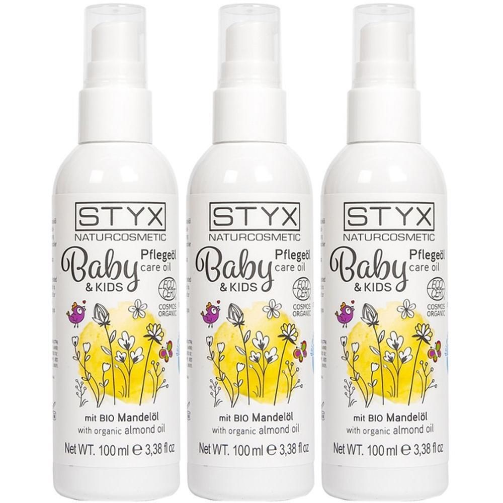 Drei weiße Pumpsprühflaschen STYX Baby & Kids Pflegeöl mit Bio Mandelöl und Blumenmotiv.