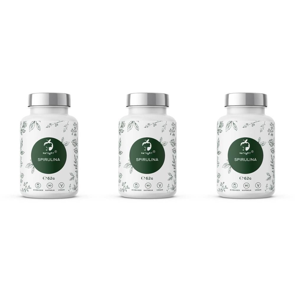 Drei weiße Flaschen mit silbernen Deckeln. Auf jeder Flasche ein grünes Etikett mit dem Schriftzug SPIRULINA und einem Logo.