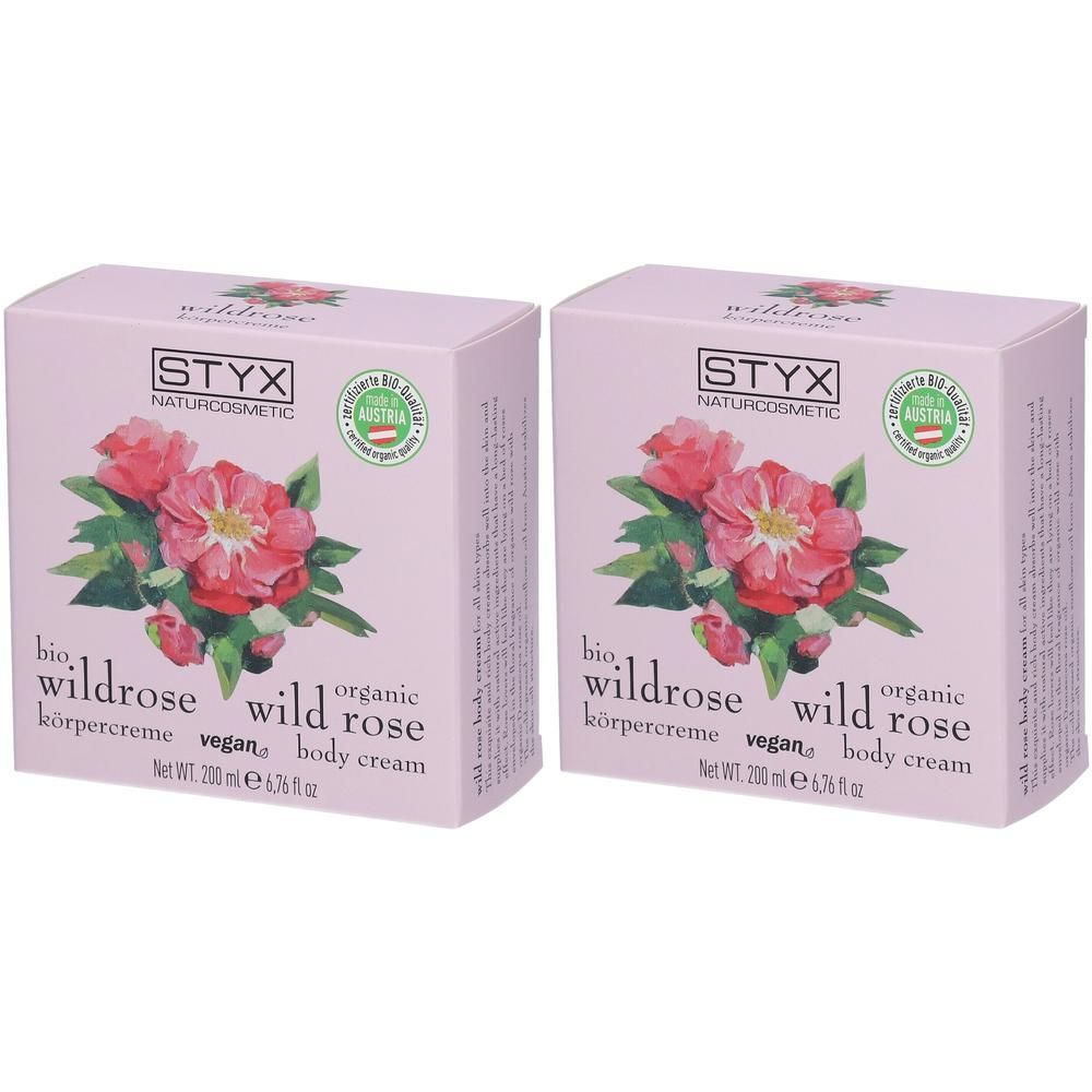 Zwei quadratische, rosa Kartons. Aufdruck: STYX, Wildrose, Körpercreme, Bio, Vegan. Mit floralem Motiv und österreichischem Qualitätssiegel.