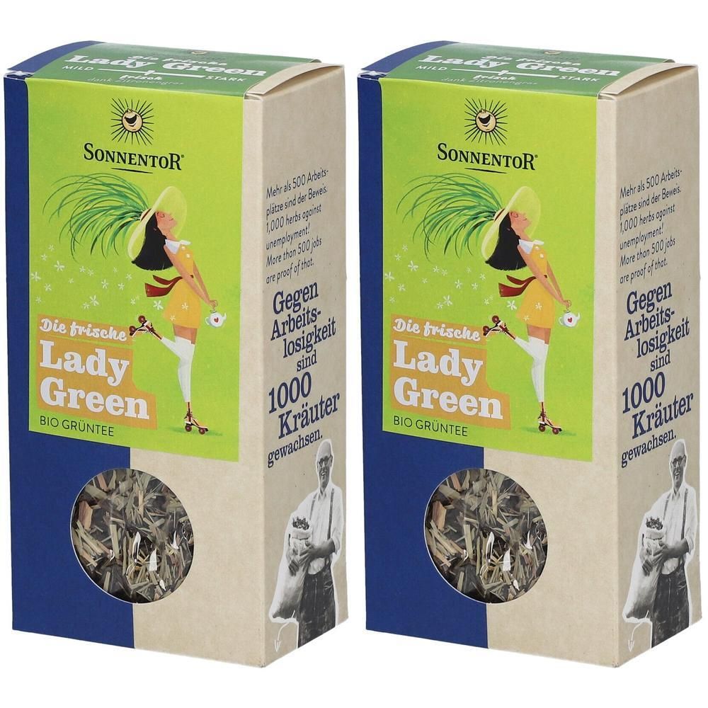 Zwei Kartons mit „Lady Green“ Tee. Aufdrucke: „Sonnentor“, Illustration einer Frau, „1000 Kräuter“. Sichtfenster mit losem Tee.