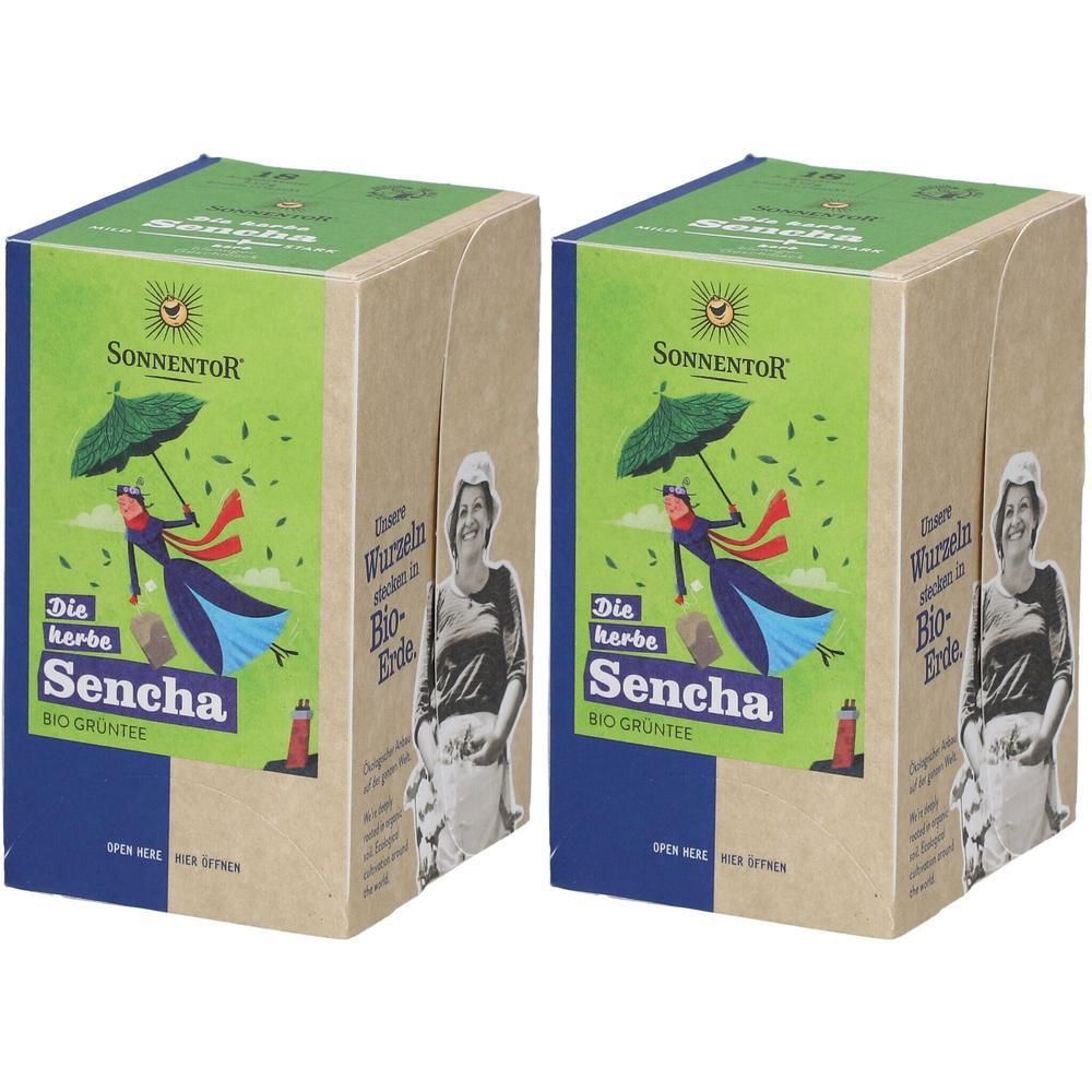 Zwei rechteckige Kartons mit grünem Deckel und blauem Boden. Aufdruck: "Sonnentor Die herbe Sencha". Illustration einer Frau mit Schirm.