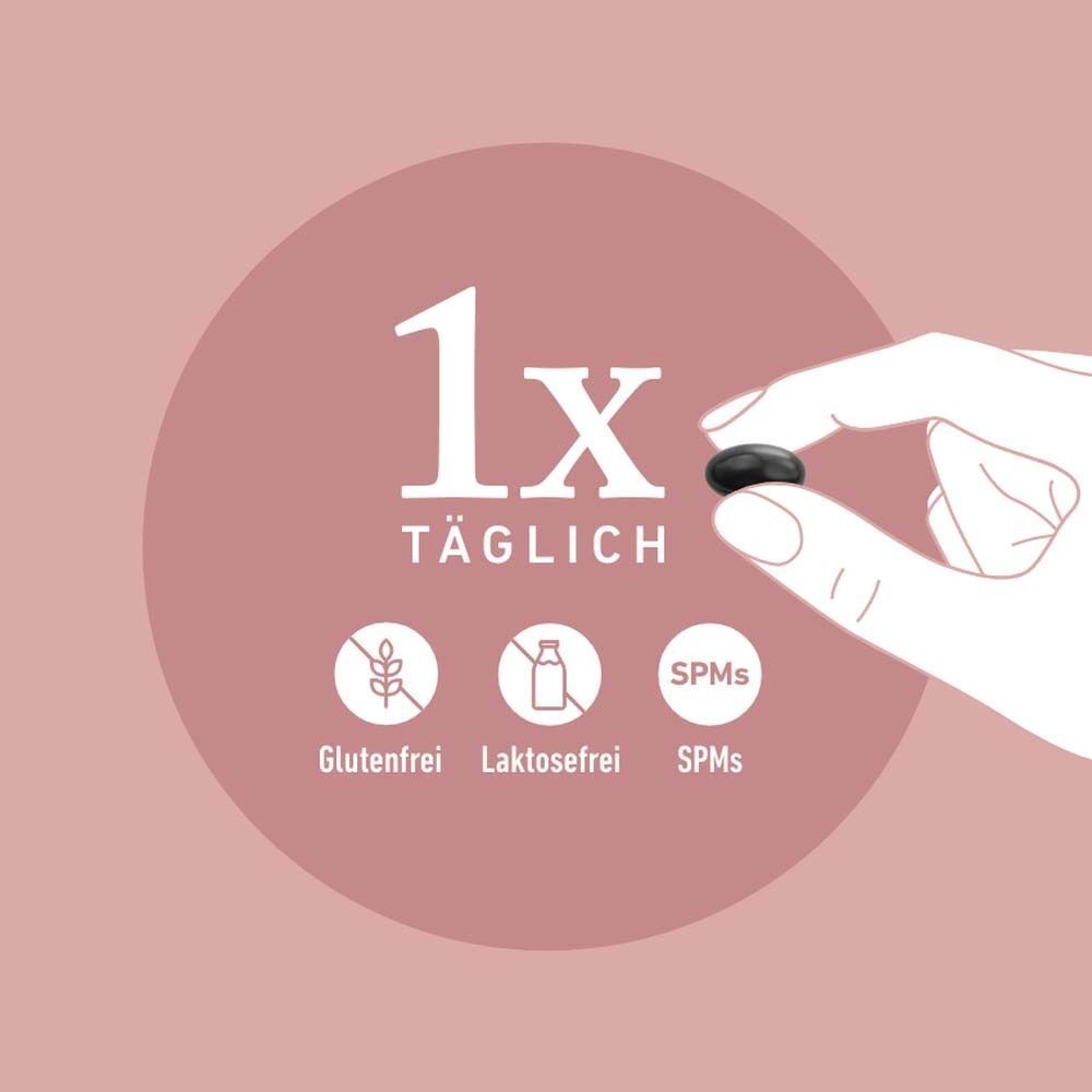 Hand hält eine schwarze Kapsel. Aufschrift: 1x täglich. Symbole für glutenfrei, laktosefrei und SPMS.