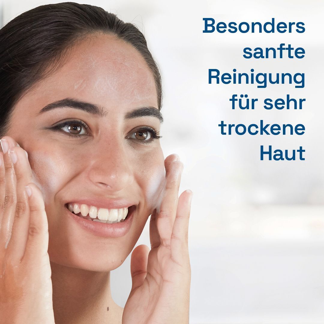 Frau wäscht ihr Gesicht mit Reinigungsschaum. Text: Besonders sanfte Reinigung für sehr trockene Haut.