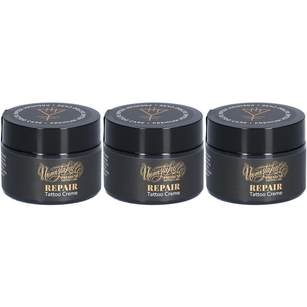 Drei schwarze Tiegel mit Deckel. Aufschrift: REPAIR Tattoo Creme. Goldfarbene Schrift auf schwarzem Hintergrund.