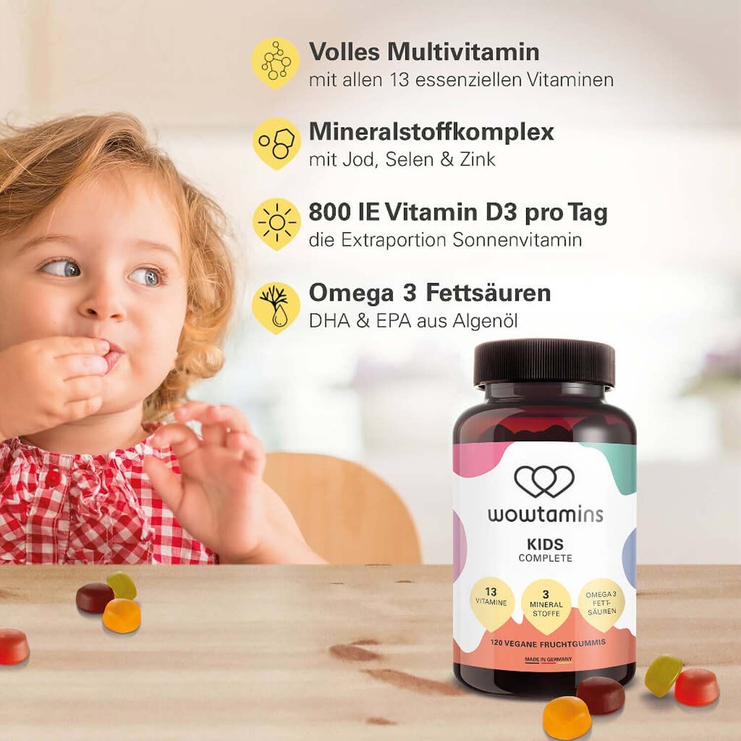 Kind is aan het eten. Daneben steht eine Flasche WOWTAMINS Kinder komplett. Aufschrift: 13 Vitamine, 3 Mineralstoffe, Omega 3 Fettsäuren.