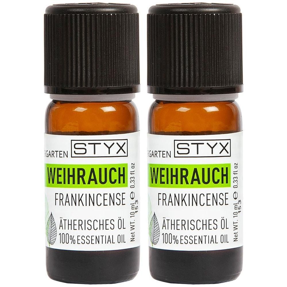 Zwei Flaschen STYX Weihrauch Ätherisches Öl. Braune Glasflaschen mit schwarzen Deckeln und weißen Etiketten mit Produktinformationen.