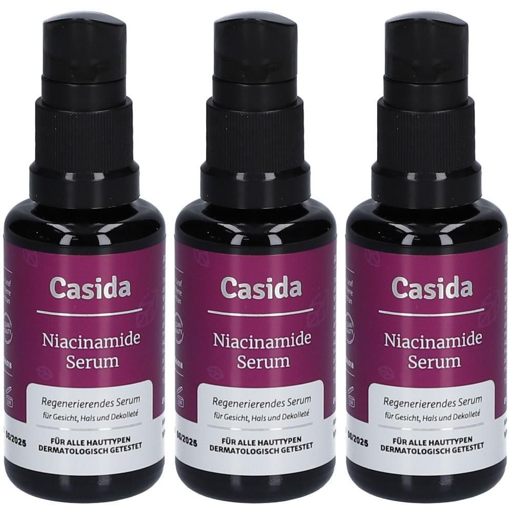 Drei Flaschen Casida Niacinamide Serum. Schwarze Pumpaufsätze, violette Etiketten mit weißer Schrift. Aufschrift: Regenerierendes Serum.